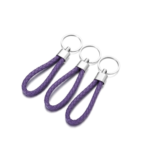 Three purple braided leather keychains with shiny metal clasps on a white background