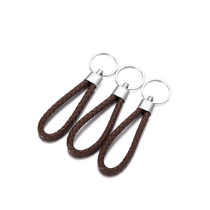 Detailed view of three brown braided PU leather keychains with polished silver metal rings