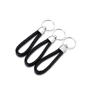 Detailed view of three braided PU leather keychains with silver metal rings on white background