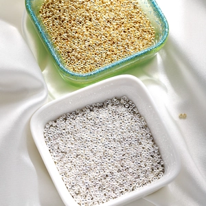 Macro shot of gold and silver plated spacer beads for DIY jewelry on white silk
