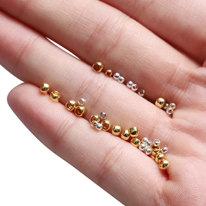 Macro view of gold and silver plated metal spacer beads held in hand for jewelry making