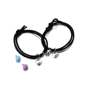Close-up of magnetic heart couple bracelets with mountain and sea metal charms