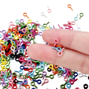 Primer plano de armellas pequeñas de colores para bisutería sujetas con los dedos
