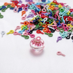 Detalle de un cáncamo de tornillo rosa fijado en bola de resina con flor seca