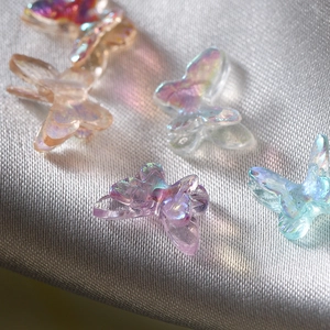 Iridescent resin butterfly charms for DIY crafts and jewelry on silk fabric background