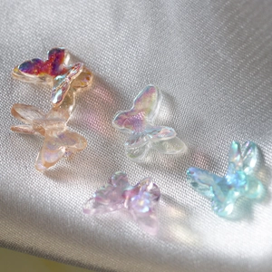 Macro detail of colorful aurora resin butterfly charms for DIY nail art and jewelry making