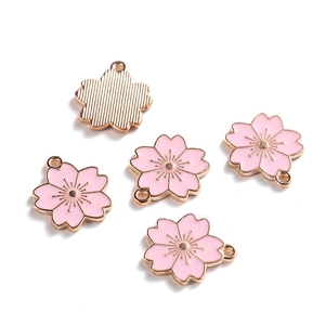 Detail van roze emaille kersenbloesem hangers met roségoud metaal voor DIY-sieraden
