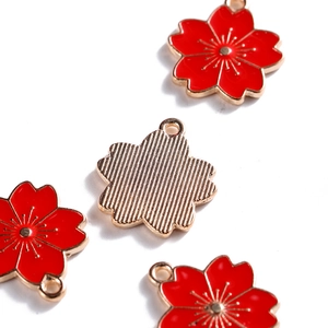 Macro-opname van kersenbloesemhangers met rood emaille en gouden getextureerde achterkant