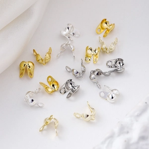 Detailed view of 18K gold and silver calotte ends on white silk background
