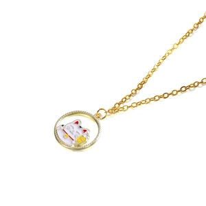 Close-up of golden Maneki-neko pendant with white enamel finish and dainty chain necklace