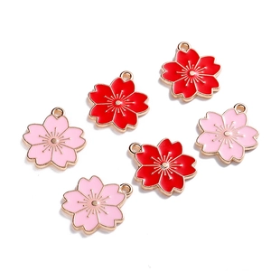 Detail van roze en rode kersenbloesem hangers voor DIY sieraden met gouden afwerking