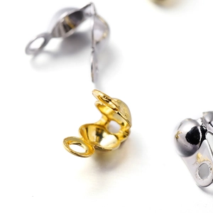 Macro shot of 18K gold and silver bead tips clam shell jewelry connectors for DIY making