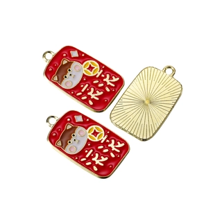 Macro detail of alloy pendants with golden frames and red enamel festive patterns