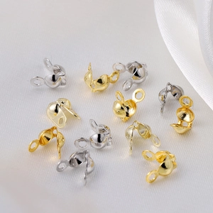 Detailed macro view of 18K gold and silver plated bead tip covers for jewelry making