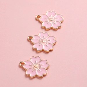 Detailopname van roze kersenbloesem hangers met goudlaag voor DIY sieraden