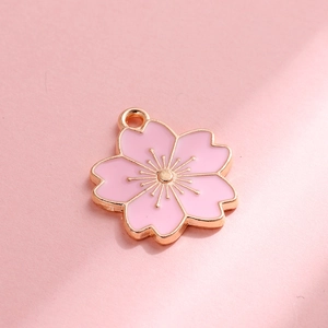 Macro-opname van roze emaille kersenbloesem hanger met goud voor DIY-sieraden