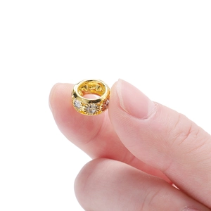 Vue macro d'une perle d'espacement dorée creuse de 10mm avec zircon blanc pour bijoux