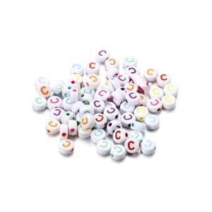 Flat lay of white acrylic round beads with colorful letter C for DIY jewelry making