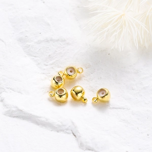 Dettaglio di cinque perline distanziatrici placcate oro 18K con inserto in silicone DIY