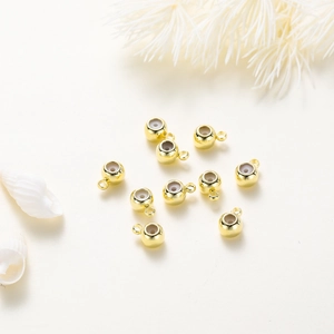 Dettaglio macro di perle scorrevoli placcate oro 18K con nucleo in silicone e anello