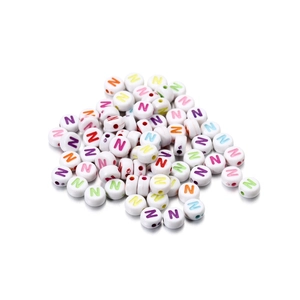 Macro shot of white acrylic round letter N beads with colorful printing for DIY jewelry making