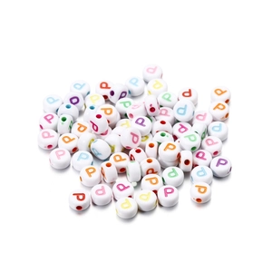 Close-up of white acrylic round beads with colorful letter P for DIY jewelry making