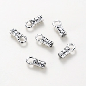 Close-up of polished silver star embossed cylinder cord end caps for jewelry making