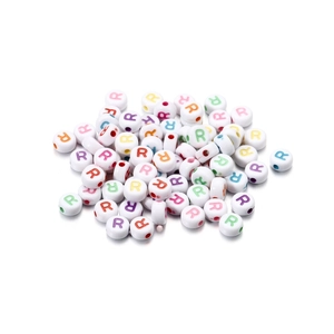 Macro shot of white acrylic round beads with colorful printed letter R for DIY jewelry making