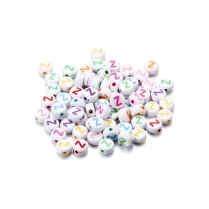 Close-up of white acrylic round beads with colorful engraved letter Z for DIY jewelry