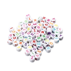 Macro detail of white round acrylic letter beads with colorful A-Z alphabet for DIY jewelry