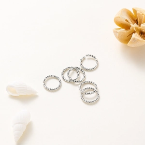 Détail des anneaux ouverts torsadés argentés avec texture tressée pour création bijoux