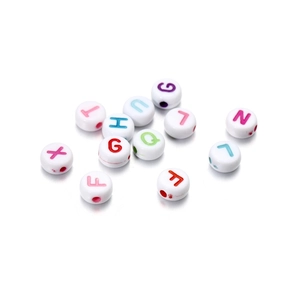 Macro shot of white acrylic round beads with colorful engraved letter D for DIY jewelry