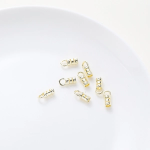 Close-up of 18K gold-plated cylindrical jewelry connectors with textured finish for DIY