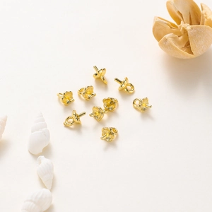 Close-up of 10 gold-plated pearl bail pin connectors for jewelry making with hanging loops