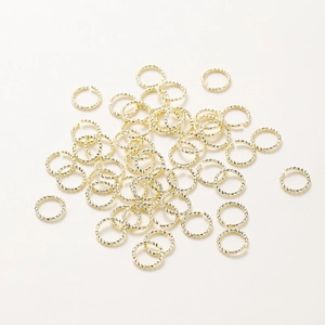 Détail macro d'anneaux de jonction torsadés plaqués or 18K pour la création de bijoux