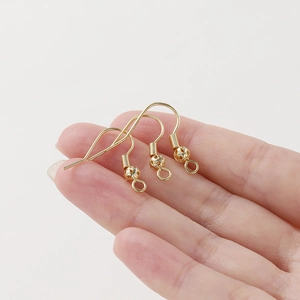 Vista macro de ganchos para pendientes bañados en oro 18K con bola y muelle para joyería