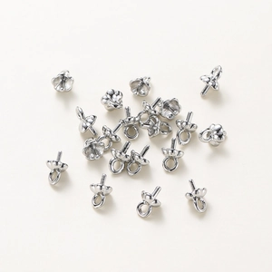 Macro view of silver petal-shaped pearl bails with pins for DIY jewelry making