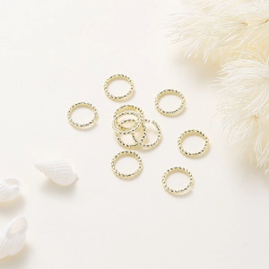 Gros plan d'anneaux de jonction torsadés plaqués or 18 carats avec texture en spirale