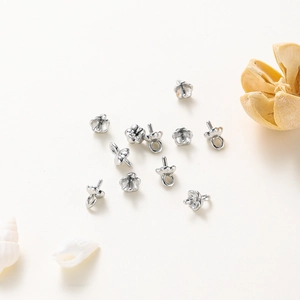 Detailed view of silver flower petal bead caps and pegs for DIY jewelry making