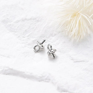 Macro view of polished silver pearl cup bails and peg connectors for jewelry making
