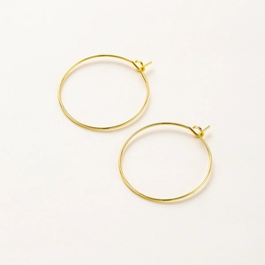 Detalle de pendientes de aro minimalistas bañados en oro 18K con cierre de gancho DIY