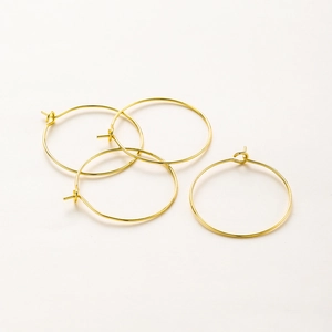 Primer plano de aros de pendientes bañados en oro de 18K con cierre de gancho