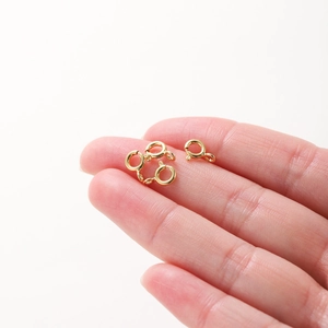 Hand holding 18K gold plated copper spring ring clasps for DIY jewelry necklaces
