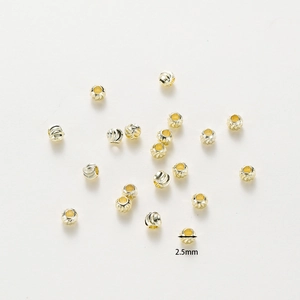 Macro view of 2.5mm 18K gold-plated copper beads with detailed spiral carved textures