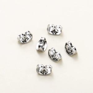 Macro view of six silver butterfly ear backs with a polished mirror finish for jewelry