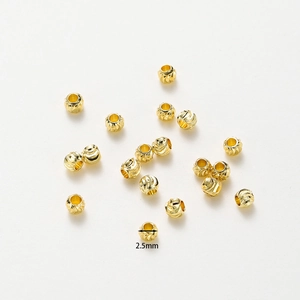 Macro shot of 2.5mm 18K gold-plated copper beads with fine spiral texture for DIY jewelry