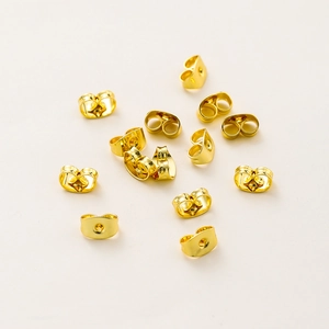 Macro detail of 18K gold plated copper butterfly earring backs with polished finish