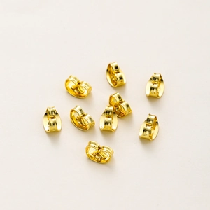Macro shot of 18K gold-plated butterfly earring backs showing premium mirror finish