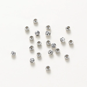 Macro shot of silver textured copper beads with swirl pattern for DIY jewelry making