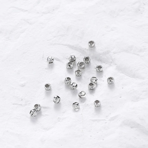 Macro detail of spiral textured silver beads for DIY jewelry making on stone background